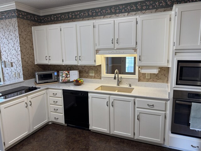 kitchen with white cabinets, stainless steel appliances, wallpapered walls, and a sink