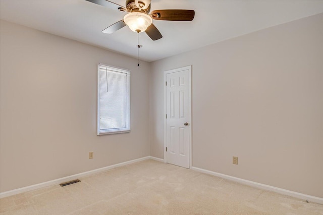 empty room with light carpet, baseboards, visible vents, and a ceiling fan