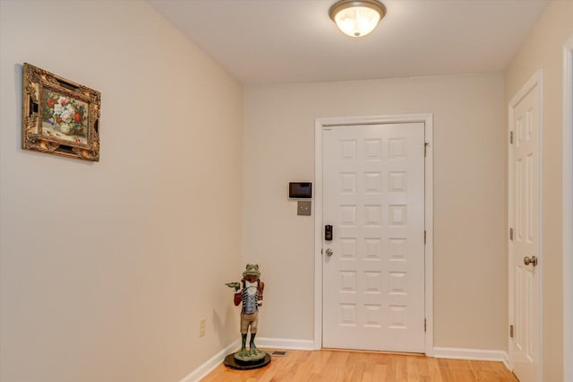 foyer entrance featuring light wood-type flooring and baseboards