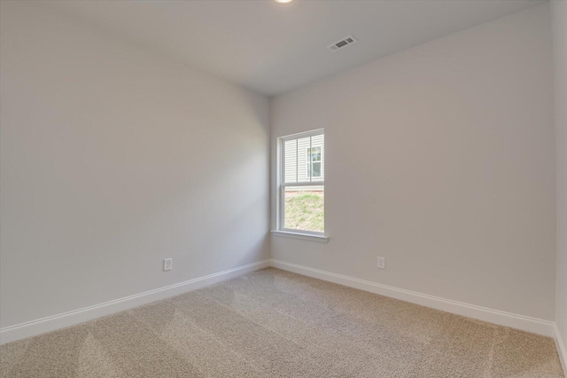unfurnished room with light colored carpet, visible vents, and baseboards