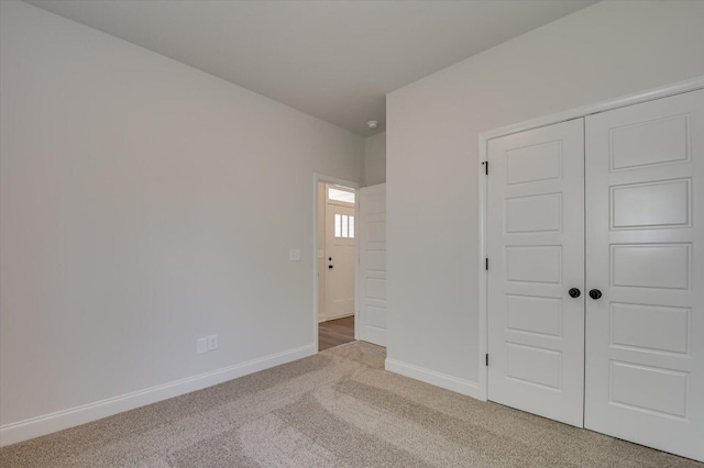 unfurnished bedroom with a closet, carpet, and baseboards