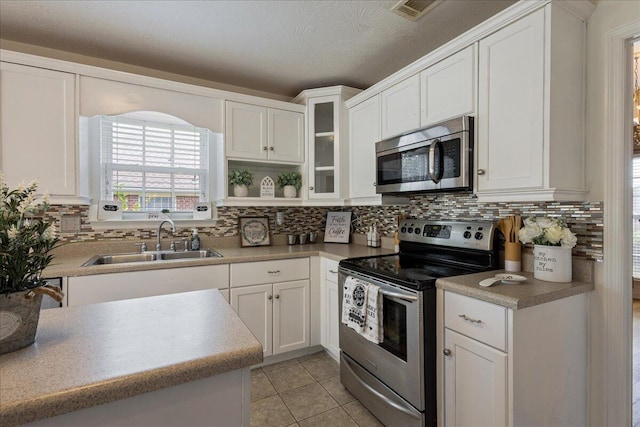 2071 Lake Forest Dr, Grovetown, GA 30813 - kitchen featuring appliances with stainless steel finishes, white cabinets, light tile patterned flooring, tasteful backsplash, and a textured ceiling