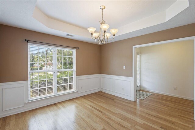 2071 Lake Forest Dr, Grovetown, GA 30813 - spare room featuring a chandelier, a tray ceiling, light wood-style floors, and a wainscoted wall