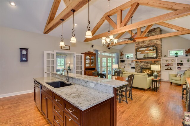 203 Jacque Cir, Mccormick, SC 29835 - kitchen with french doors, a sink, light wood finished floors, a stone fireplace, and decorative light fixtures