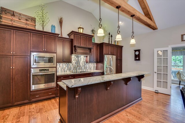 203 Jacque Cir, Mccormick, SC 29835 - kitchen with stainless steel appliances, a breakfast bar area, backsplash, light wood-style flooring, and beam ceiling
