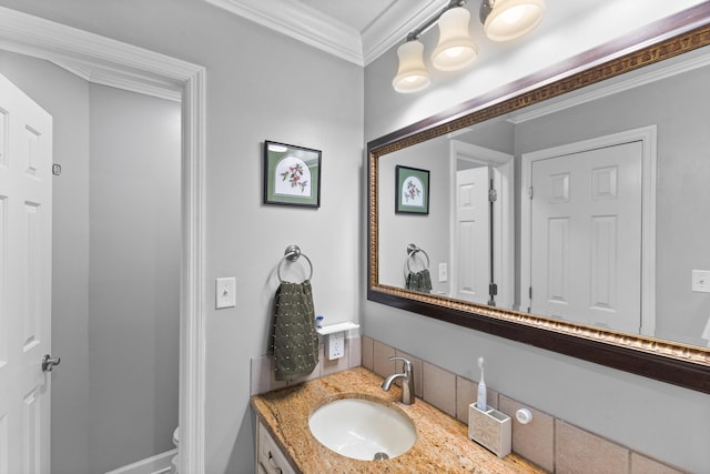 bathroom with toilet, vanity, and ornamental molding