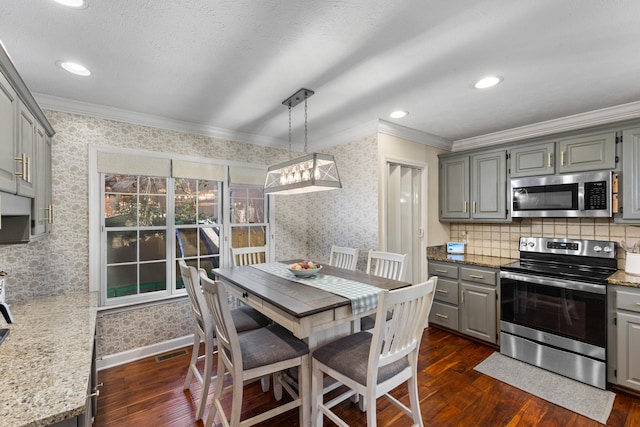 dining area with visible vents, dark wood finished floors, crown molding, wallpapered walls, and baseboards