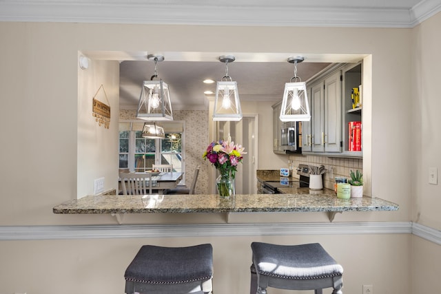 kitchen with stone countertops, decorative backsplash, appliances with stainless steel finishes, pendant lighting, and crown molding