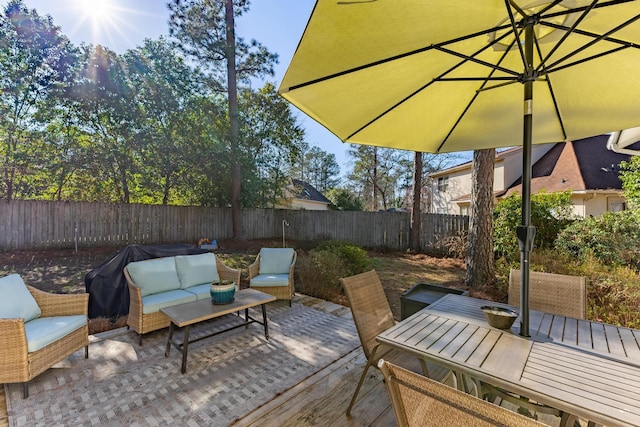 deck featuring outdoor lounge area, a fenced backyard, outdoor dining space, and a patio area