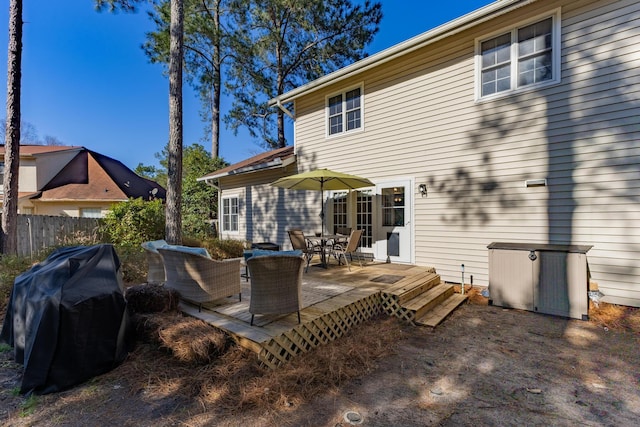 back of property featuring outdoor dining area, fence, and a wooden deck