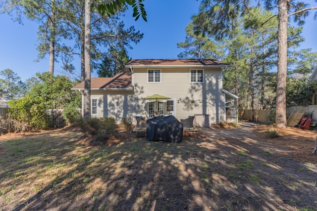 rear view of house featuring fence