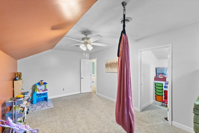 rec room featuring a textured ceiling, baseboards, carpet, and vaulted ceiling