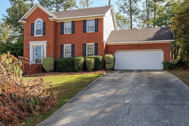 colonial inspired home with a garage and a front lawn