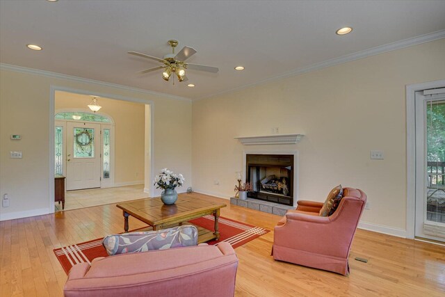 living room with ceiling fan, light hardwood / wood-style flooring, and ornamental molding