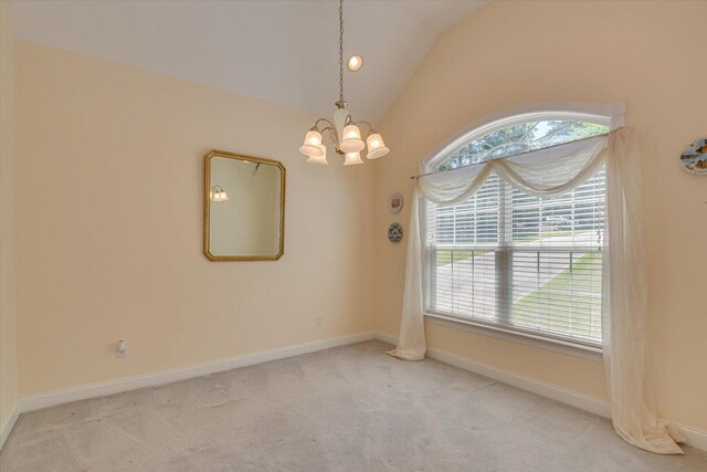 carpeted spare room featuring a notable chandelier and lofted ceiling