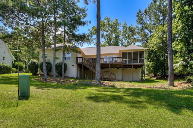 rear view of property with a yard, a deck, and a sunroom