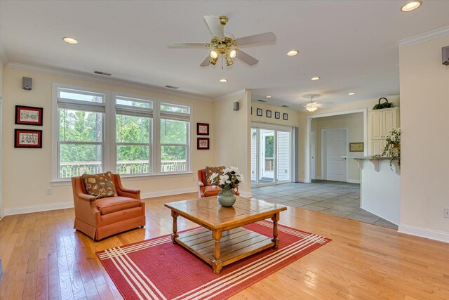 living room featuring ceiling fan, light hardwood / wood-style floors, and ornamental molding