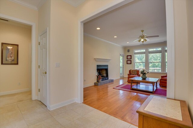 living room with crown molding, ceiling fan, and light hardwood / wood-style floors