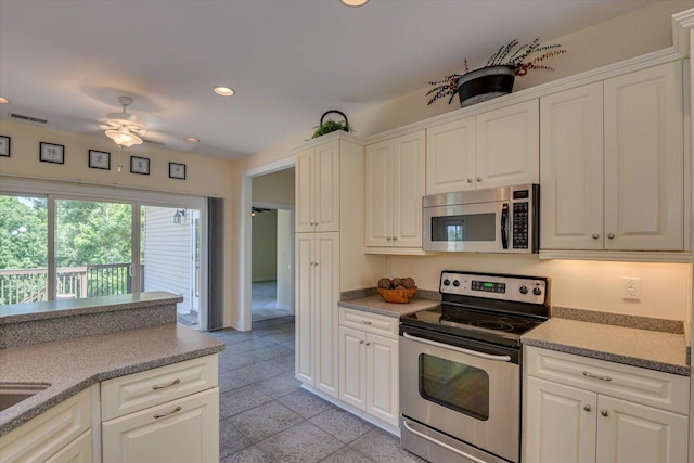 kitchen with appliances with stainless steel finishes, white cabinetry, and ceiling fan