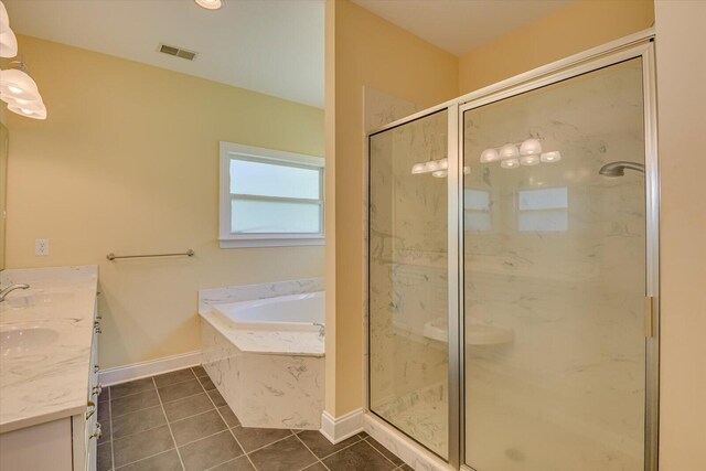 bathroom featuring tile patterned flooring, shower with separate bathtub, and vanity