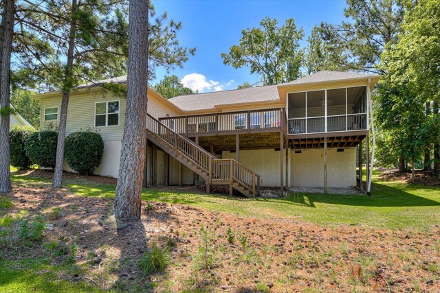 rear view of property featuring a deck and a yard