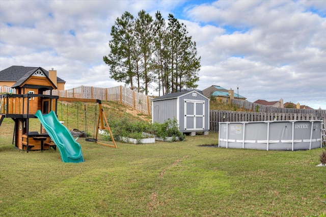 view of playground featuring a lawn and a shed