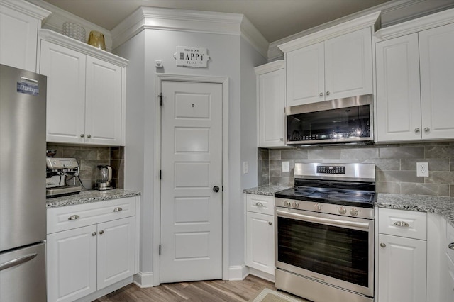 kitchen featuring white cabinetry, decorative backsplash, and stainless steel appliances