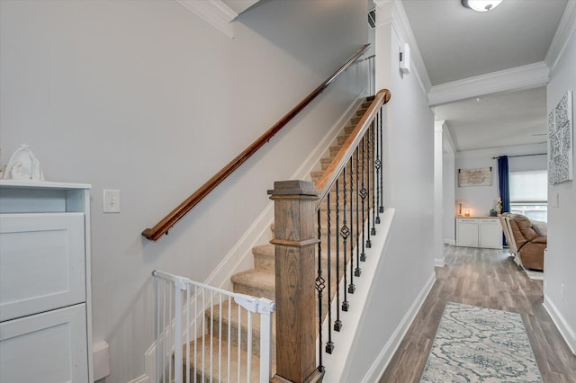 stairs featuring hardwood / wood-style floors and crown molding