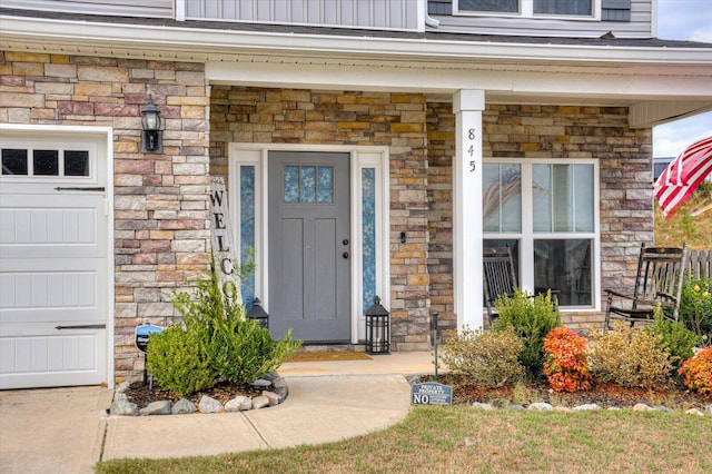 view of exterior entry with a garage and covered porch