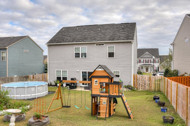 view of playground featuring a fenced in pool and a yard