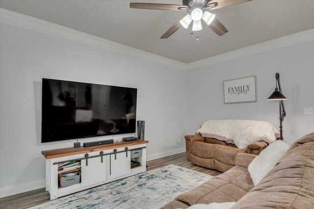 living room with hardwood / wood-style flooring, ceiling fan, and ornamental molding