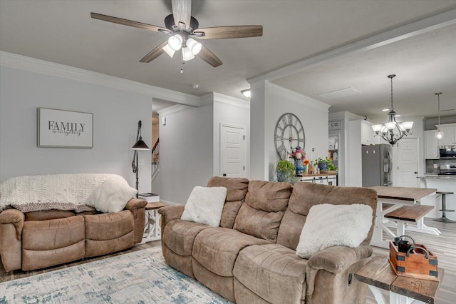 living room featuring crown molding, light hardwood / wood-style flooring, and ceiling fan with notable chandelier