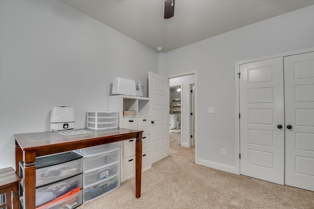 carpeted home office featuring ceiling fan