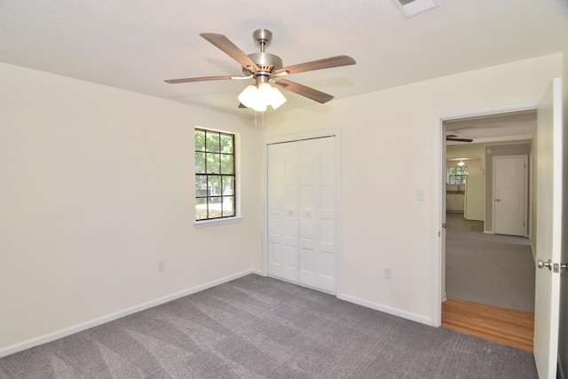 unfurnished bedroom featuring ceiling fan, a closet, and carpet floors