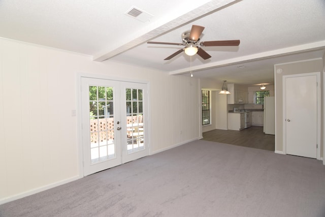 spare room featuring beamed ceiling, french doors, carpet floors, and ceiling fan