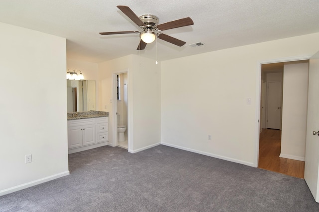 unfurnished bedroom featuring ensuite bathroom, ceiling fan, and carpet floors