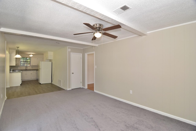 unfurnished living room with carpet, a textured ceiling, ceiling fan, and sink