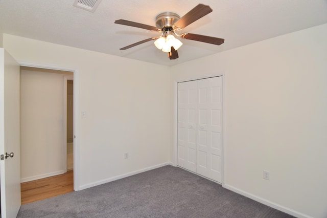 unfurnished bedroom featuring ceiling fan, a closet, and carpet