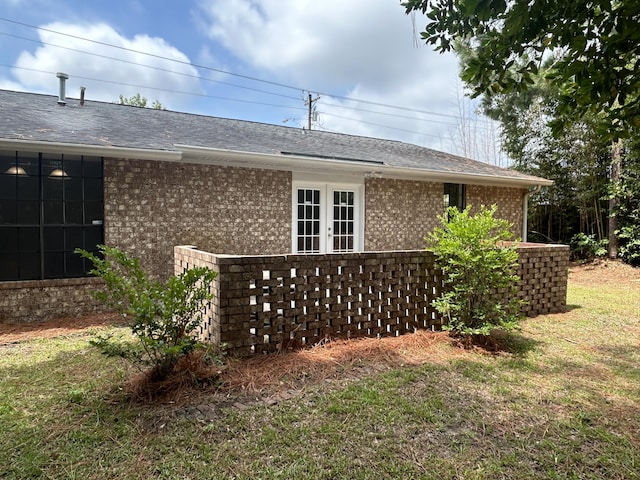 view of side of home with french doors and a yard