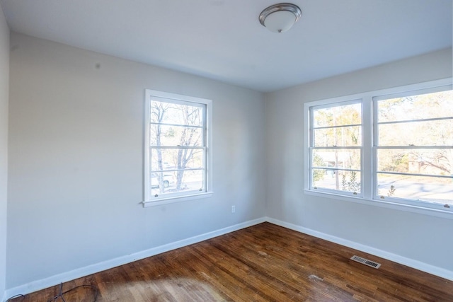 unfurnished room featuring a healthy amount of sunlight and hardwood / wood-style flooring