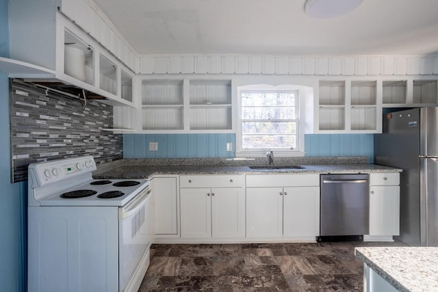 kitchen featuring light stone countertops, white cabinetry, stainless steel appliances, decorative backsplash, and sink