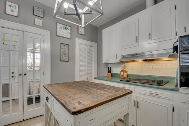 kitchen featuring white cabinets, butcher block counters, electric cooktop, and decorative backsplash