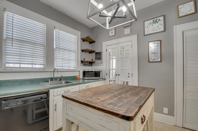 kitchen with a kitchen island, a sink, white cabinets, black dishwasher, and tasteful backsplash