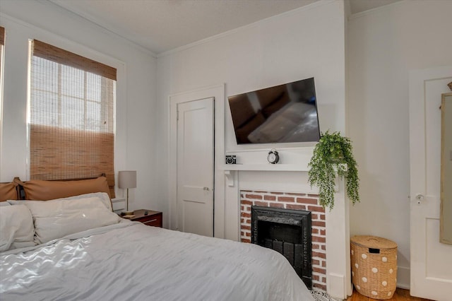 bedroom featuring crown molding and a fireplace