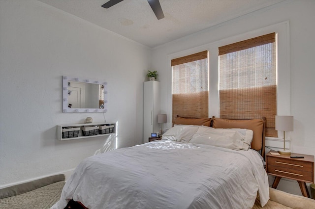 bedroom with ceiling fan and a textured ceiling