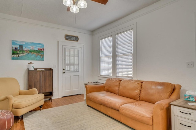 living area featuring light wood-type flooring and ceiling fan