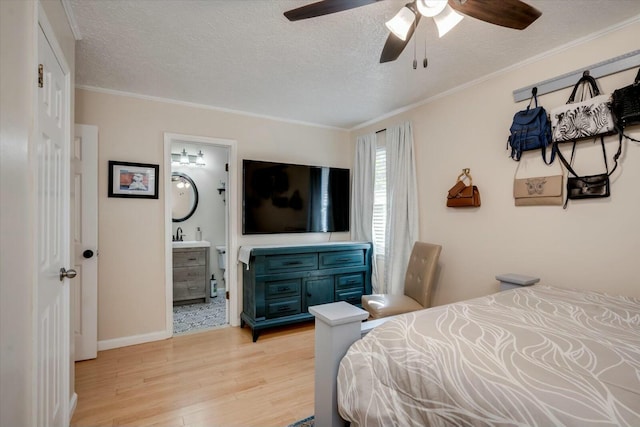 bedroom featuring a textured ceiling, connected bathroom, baseboards, light wood-style floors, and ornamental molding