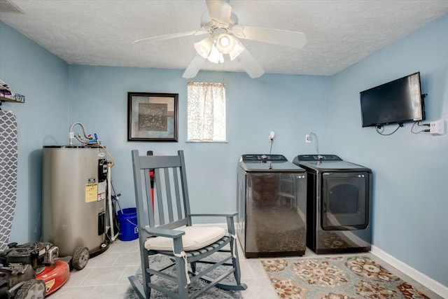 laundry room with laundry area, visible vents, washer and dryer, a textured ceiling, and water heater