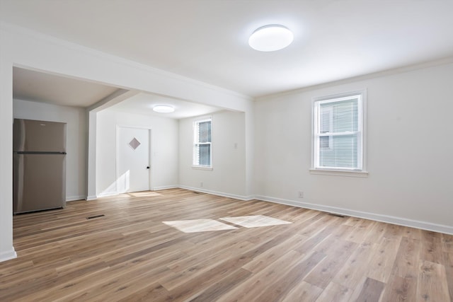 unfurnished room with crown molding and light wood-type flooring