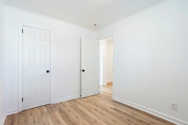 unfurnished bedroom with ornamental molding, a closet, and light hardwood / wood-style flooring